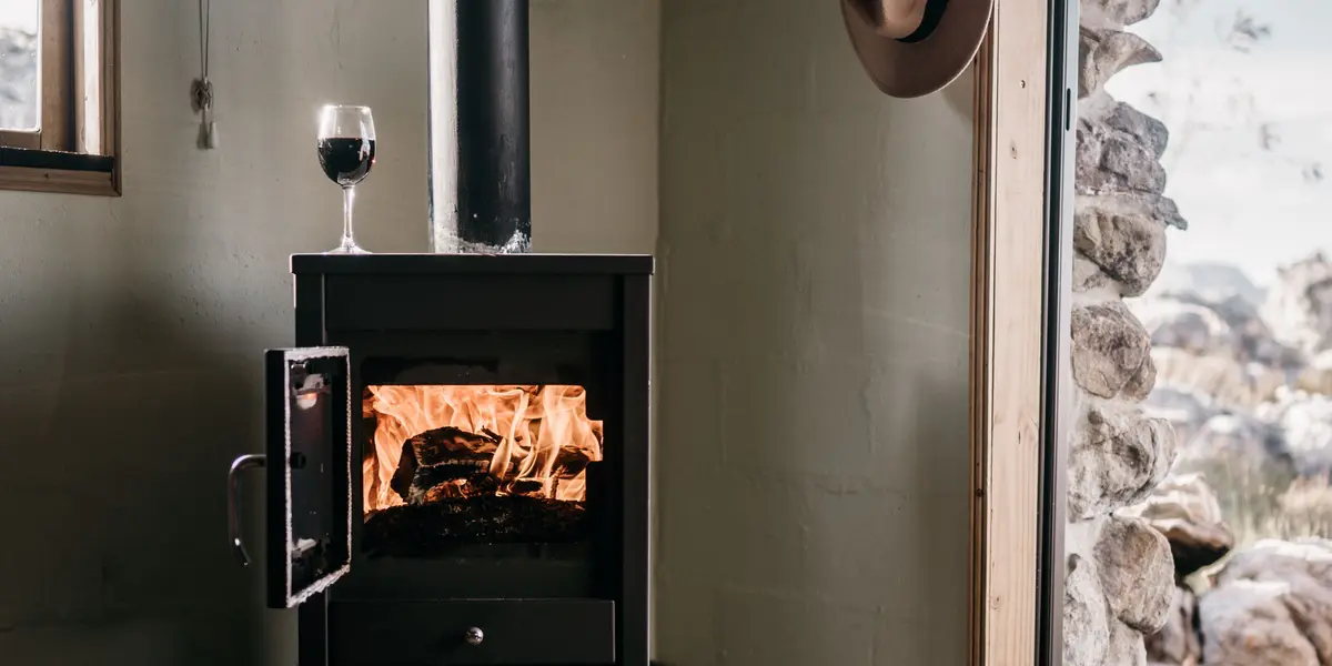 Petit poêle à bois noir allumé dans une maison récente