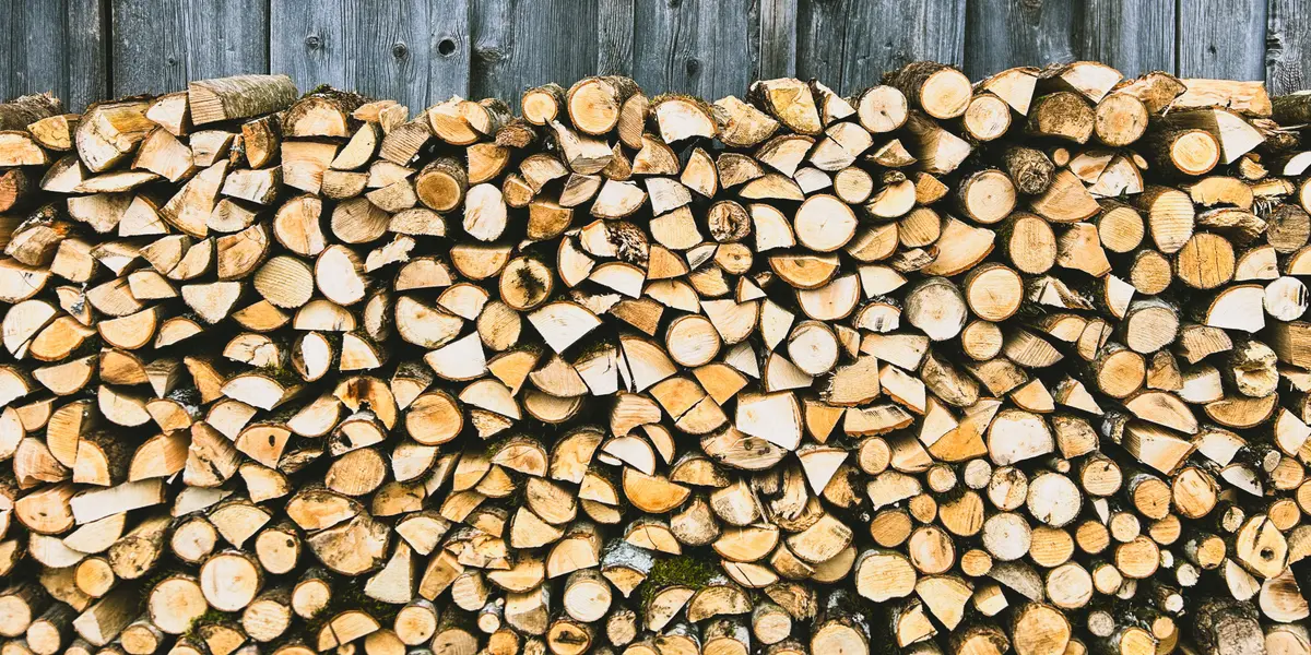 Pile de bois de chauffage fendu et rangé contre un mur